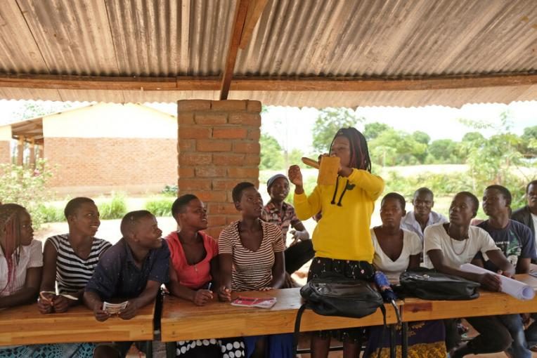 Girl demonstrates how to put on a condom at her local youth group