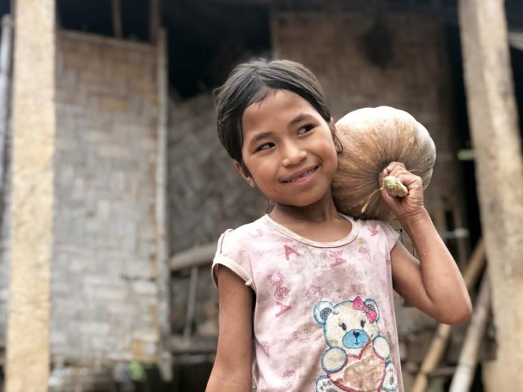 Yen Nhi with one of the vegetables her mother delivers as a shipper