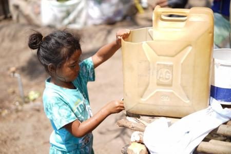  A girl washes her hands in a temporary camp in Indonesia.