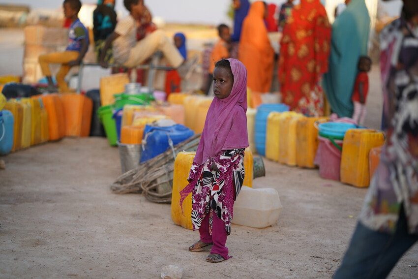 Young girl waits her turn to collect water in IDP camp.