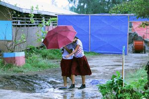 Philippines - Schoolgirls shield from rain -Plan International