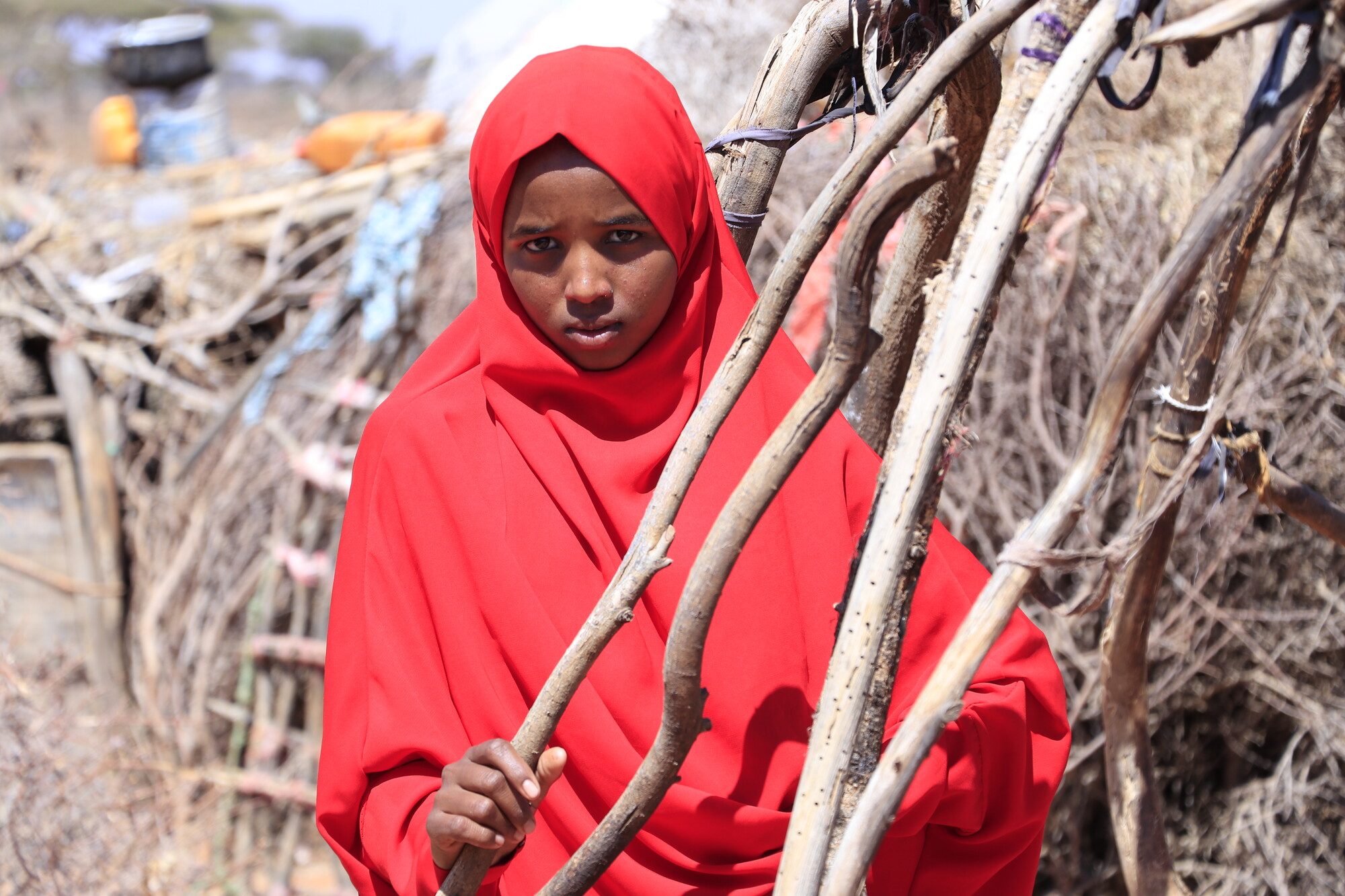 Adolescent girl, girls in emergencies, displaced girl outside her shelter, food crisis, hunger crisis.