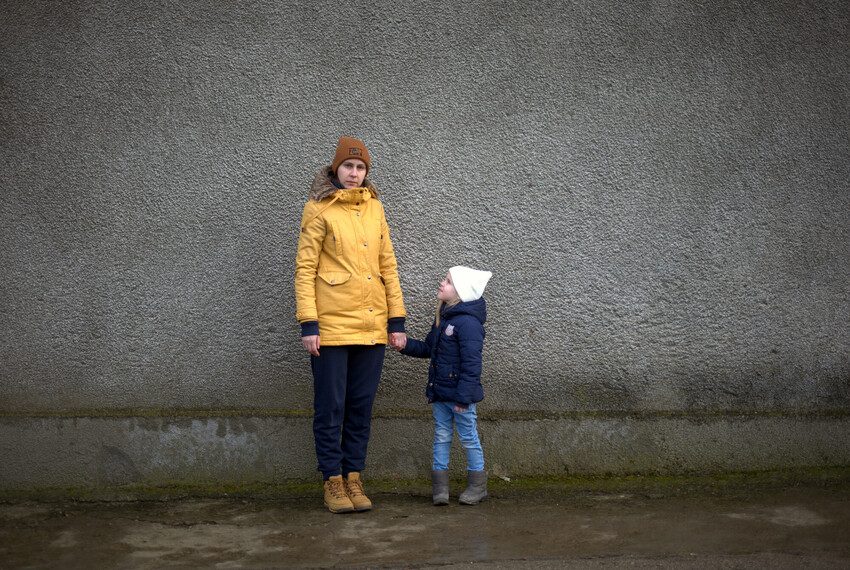 Tatiana and her 5-year-old wait for Ludobus — a play bus run by Plan International’s partner organisation.