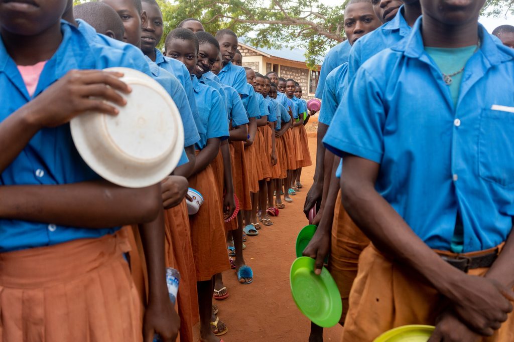 Children queue for a hot meal.