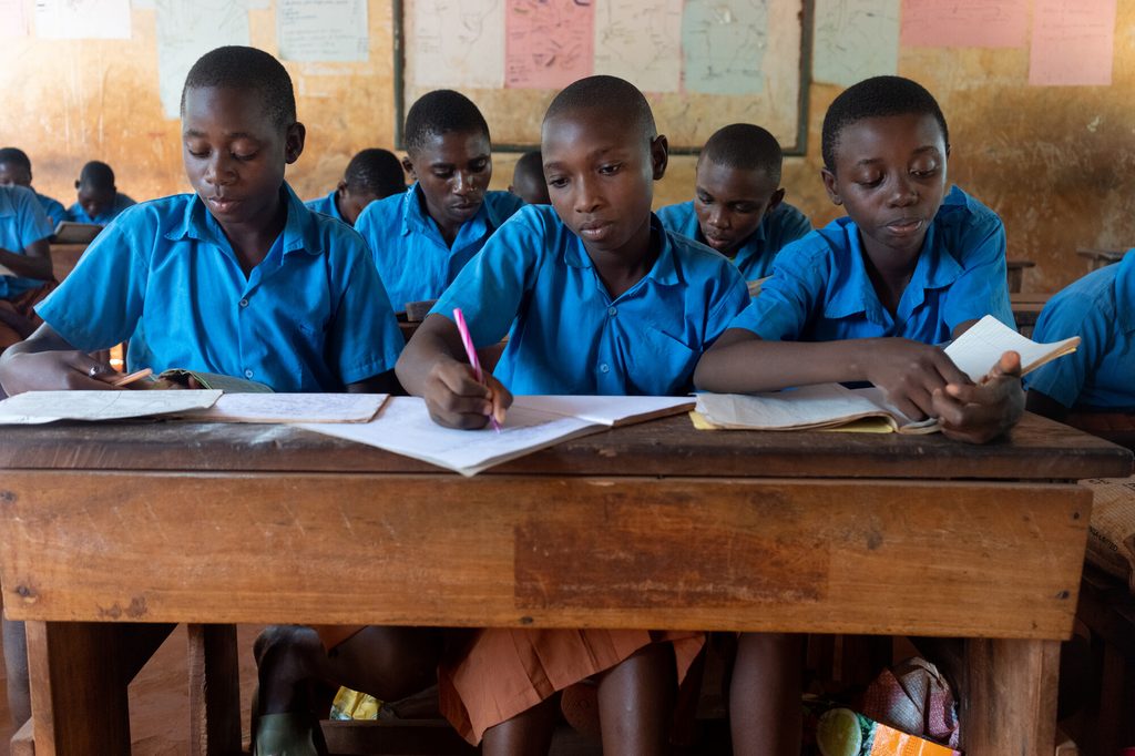 Students sit at their desks learning.