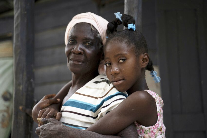 Chedeline, 13, with her grandmother at their home in South East Haiti.