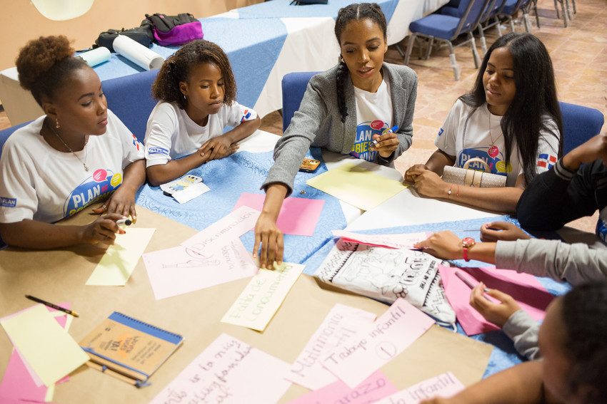 Girls discuss and write notes during a consultation with Plan International in the Dominican Republic. 