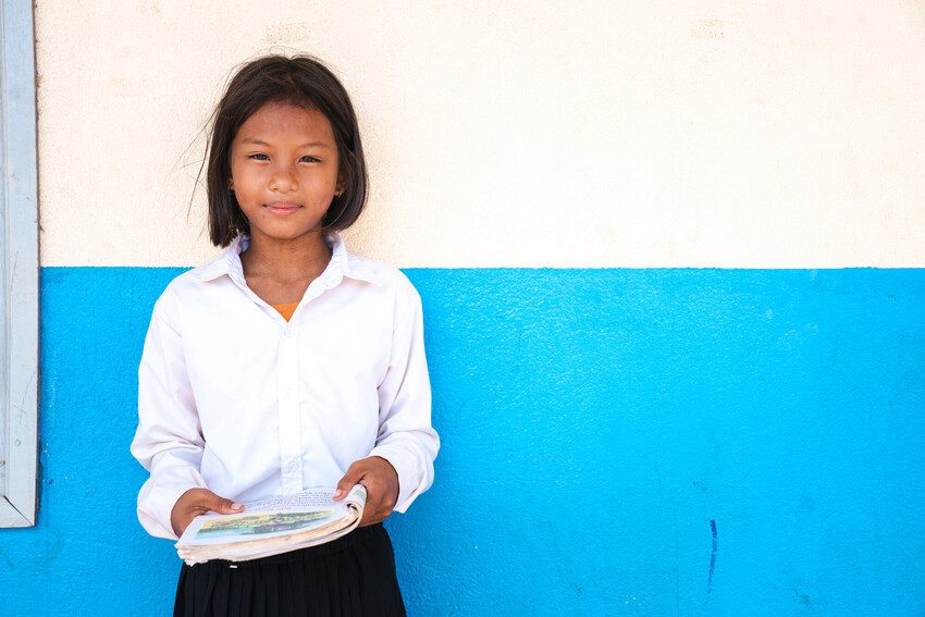 Muta, 11, Cambodia stands outside her school.