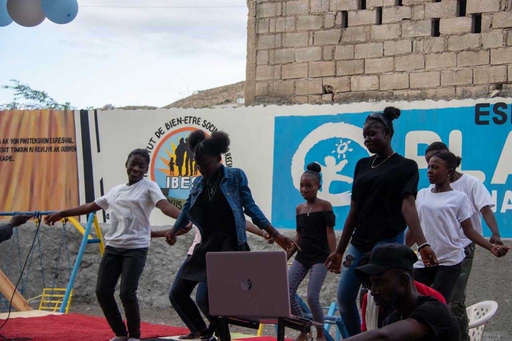 Five girls dancing on a stage during a theatre group at a child-friendly space.