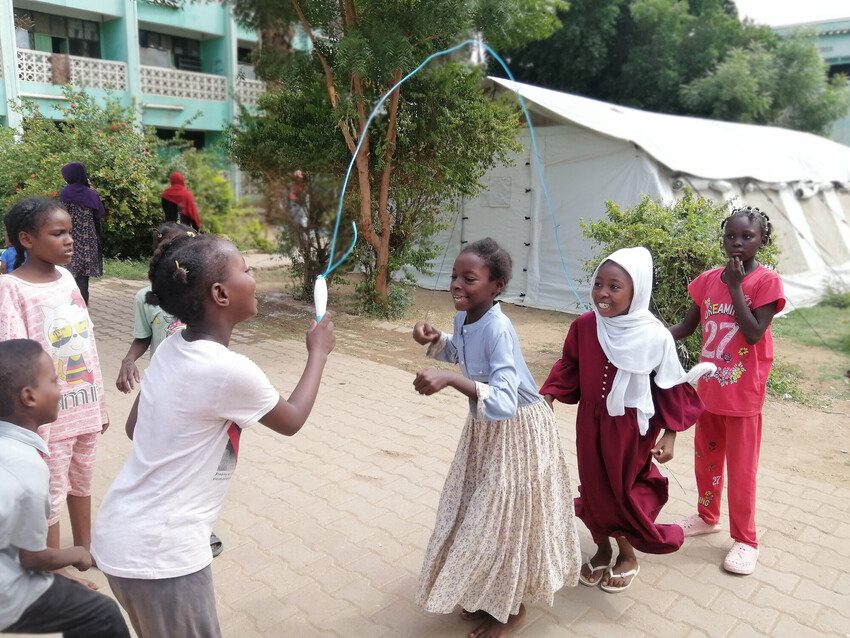 Children play with a skipping rope. 