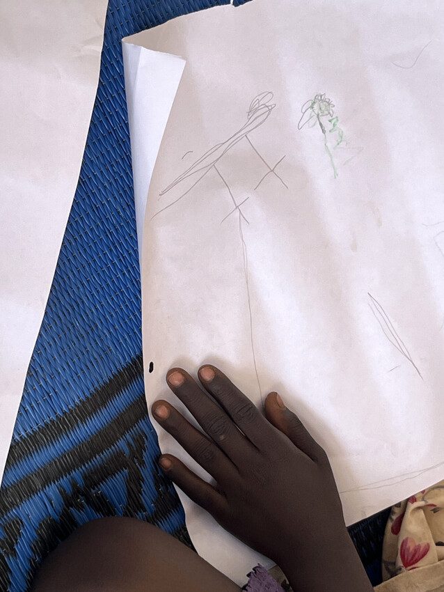 With a tiny smile on her face, four-year-old Lamia* is putting her best effort into drawing a kite. 