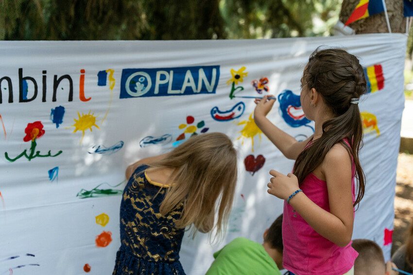 Two girls paint a banner, 