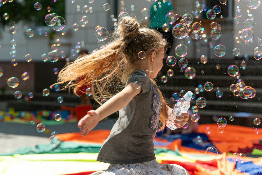 A young girl plays with bubbles.