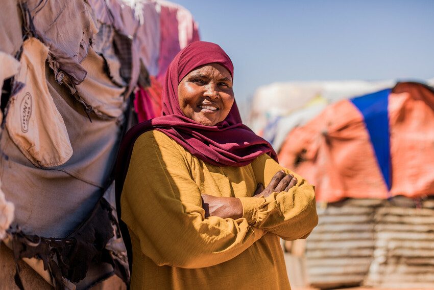 Saafi a mother who says no to FGM stands with her arms folded. 