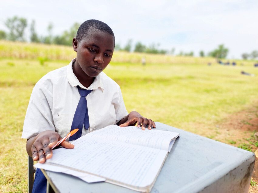 Anna who has stood firm against FGM is writing in her school notebook. 