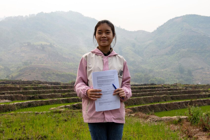 Huyen stands smiling as she explains her work to end child marriage. 