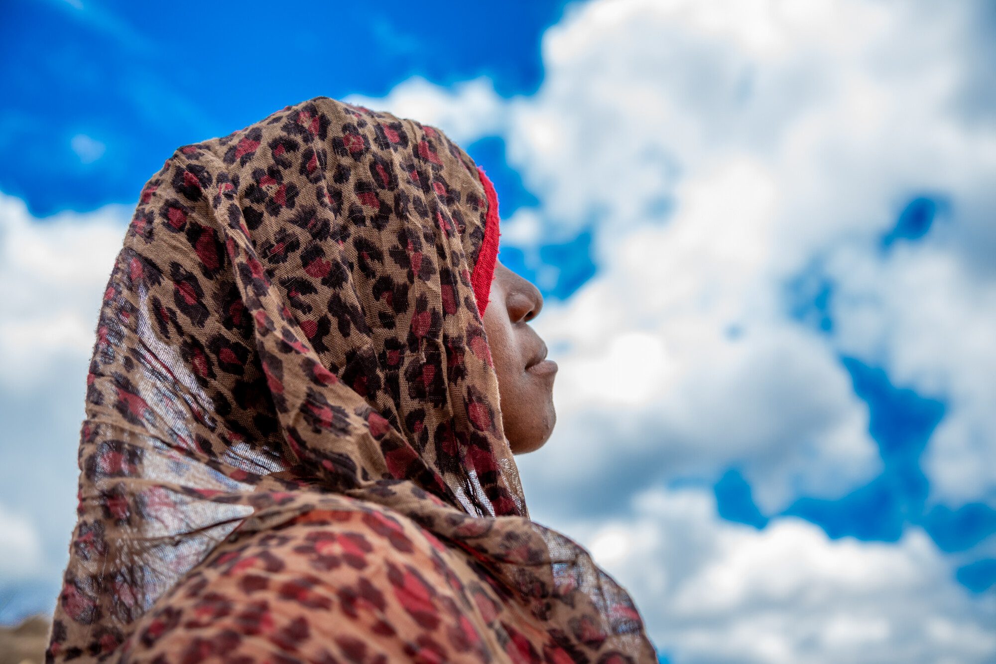 A 14 year old girls from Mozambique looks to the sky.