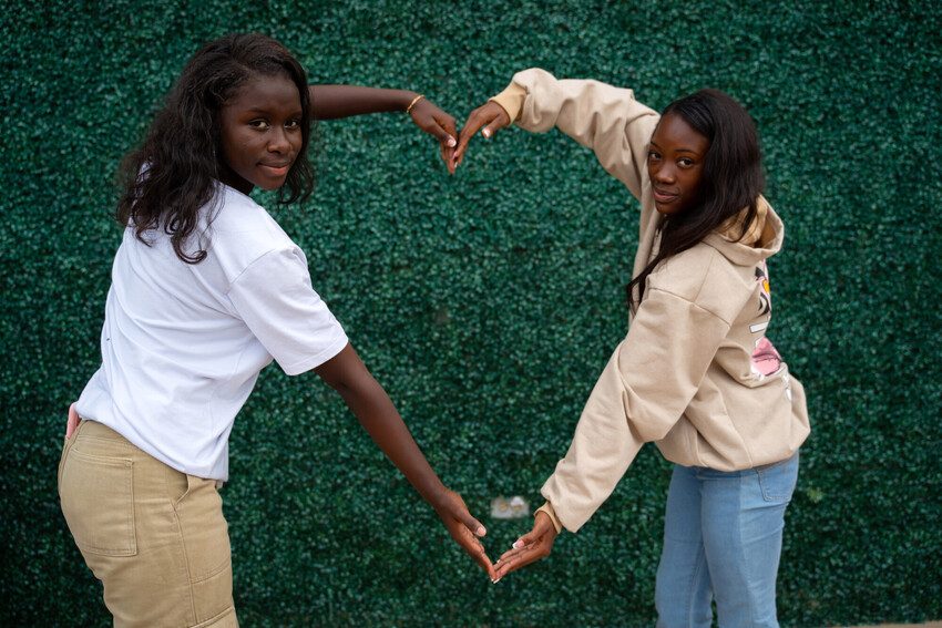 Ada Luz and Laubry use their arms to form a heart shape. 