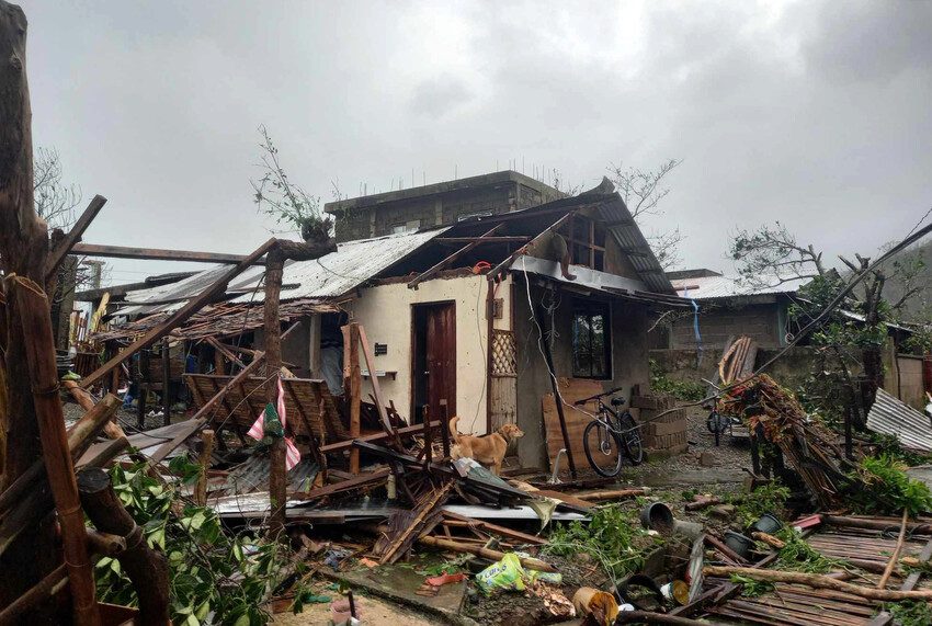 A house with severe damage from the typhoon is missing part of its roof. 