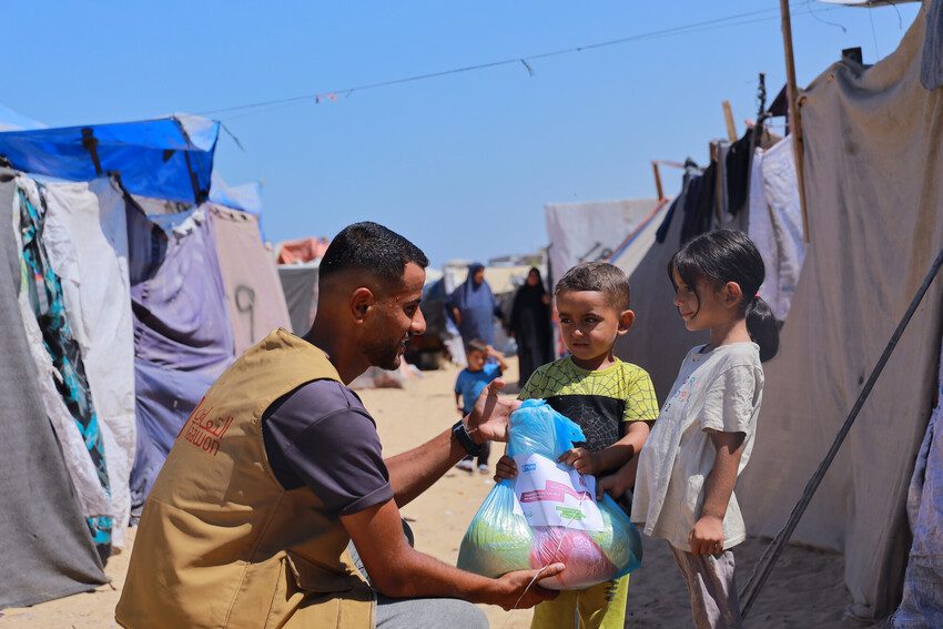 Taawon delivering food aid to children in Gaza.