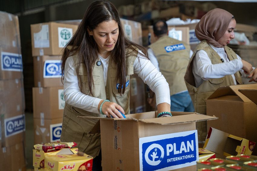 Plan International staff box up aid items for people in Gaza.