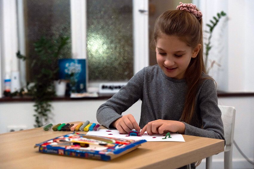 Zlata, 9, creates picture from modelling clay.