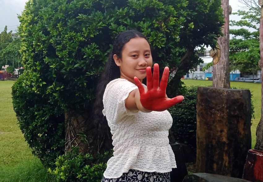 Sofia, 18, has painted her hand red to call for an end to violations against children in conflict. 