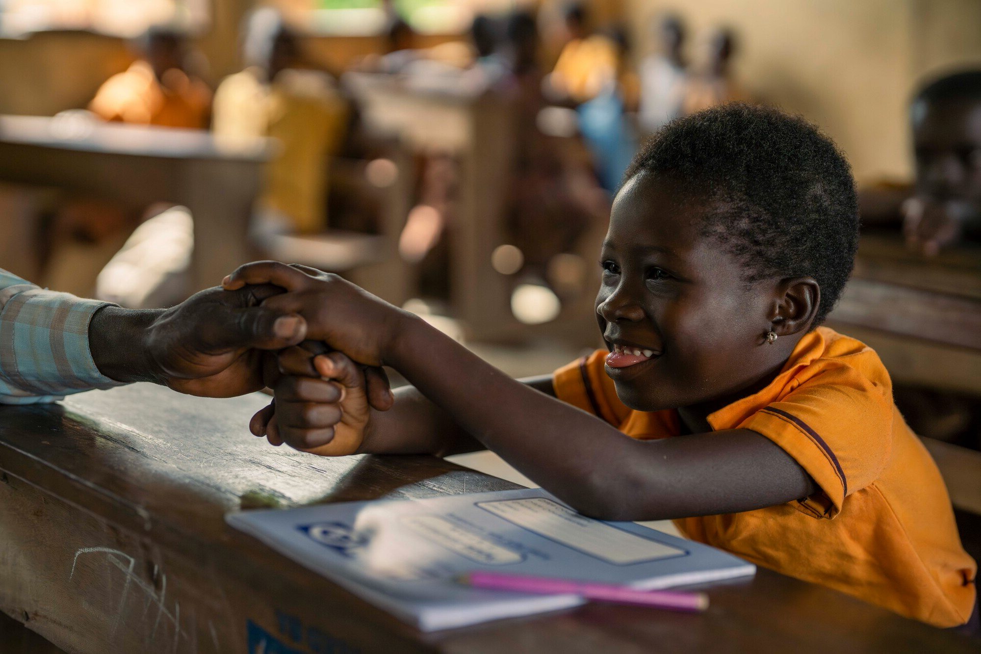 A boy smiling in a classroom.