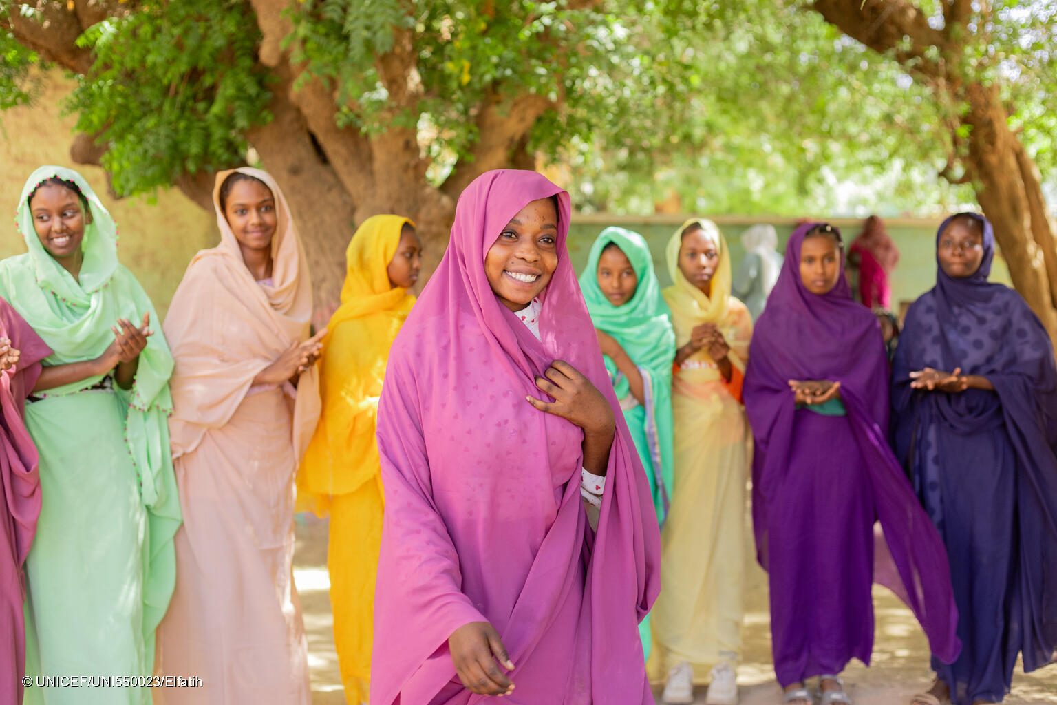 Girls in Sudan wear different coloured hijabs, smiling.