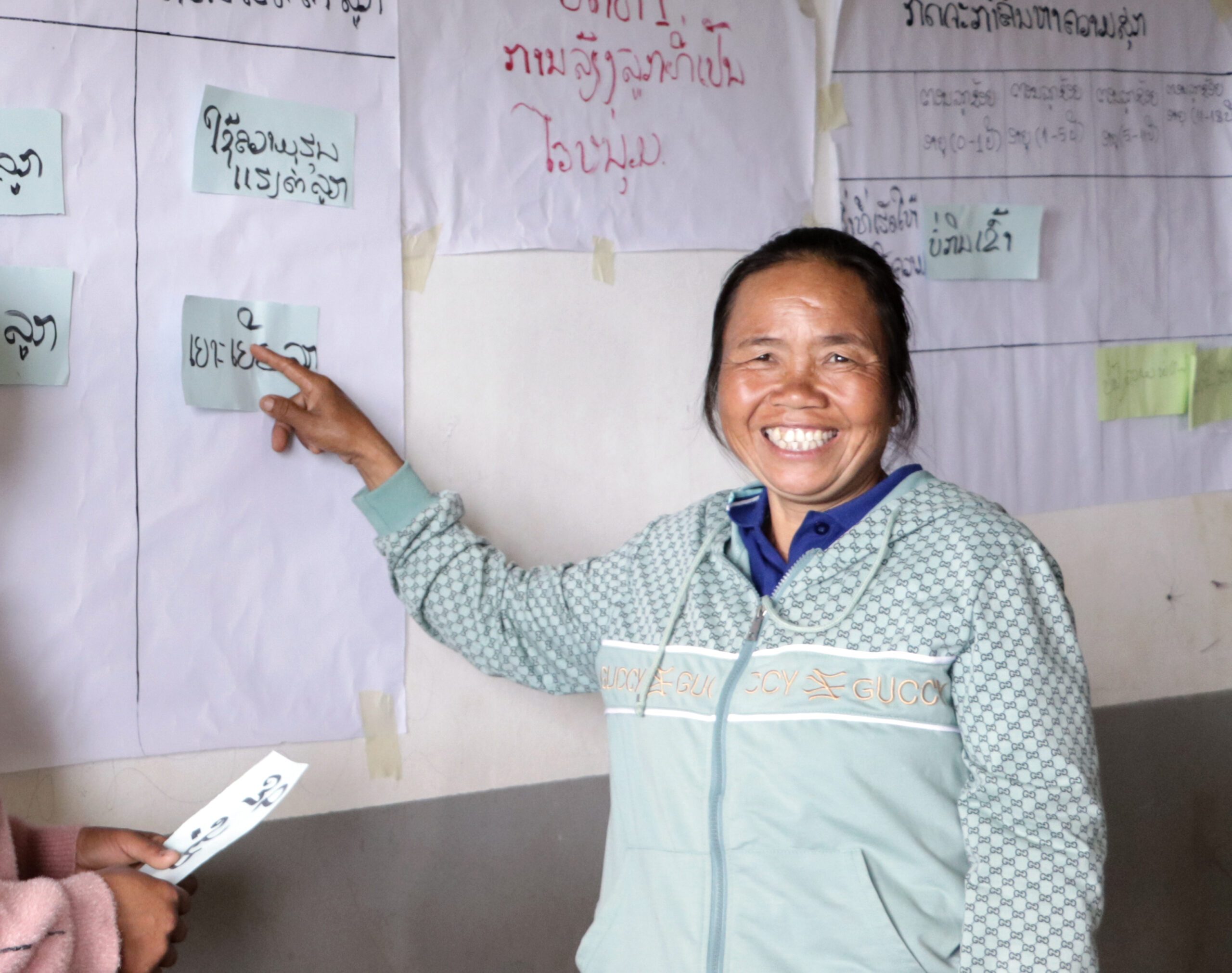 Seng points at text on the board during a parent session. 