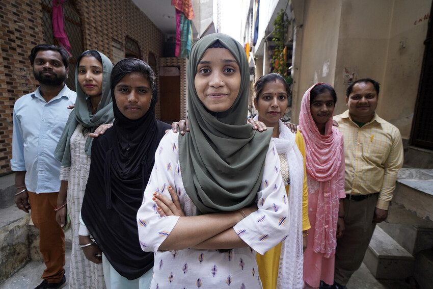 Afsana stands with arms folded with members of her youth group in India.