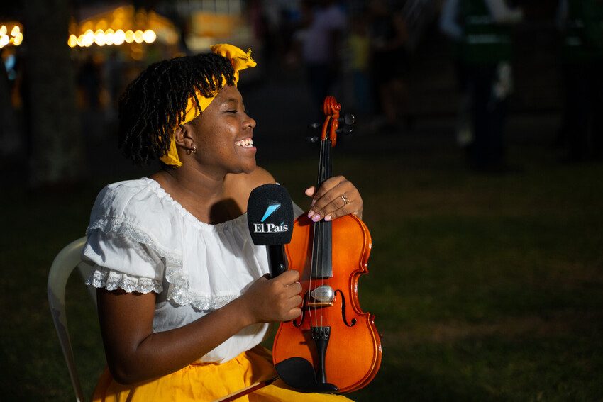 Musician Valery, 18, from Colombia, speaks into a microphone at an event.  