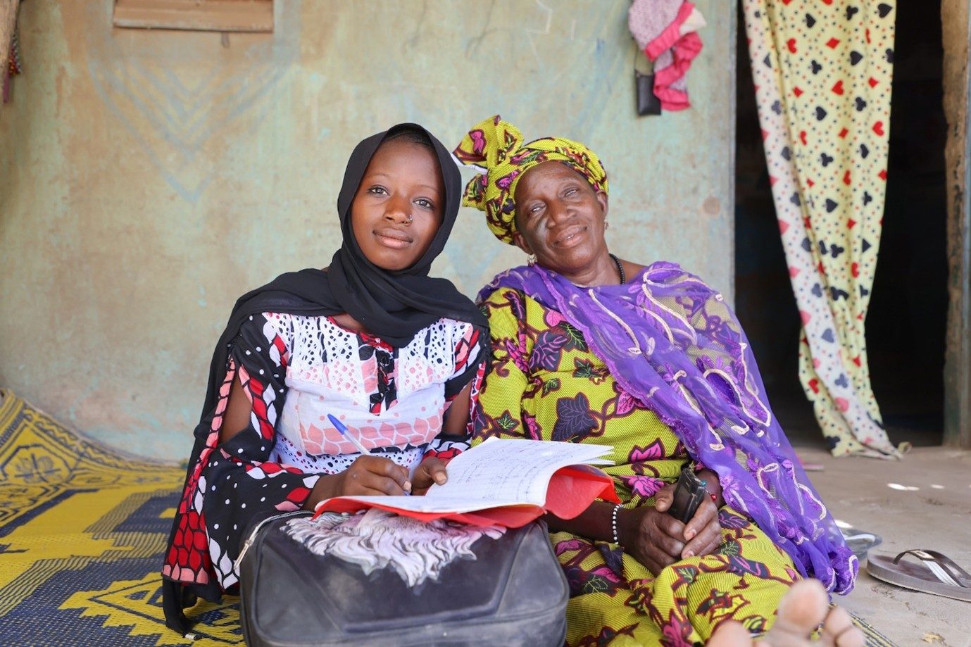 Mahawa and her mother sit next to each other. 