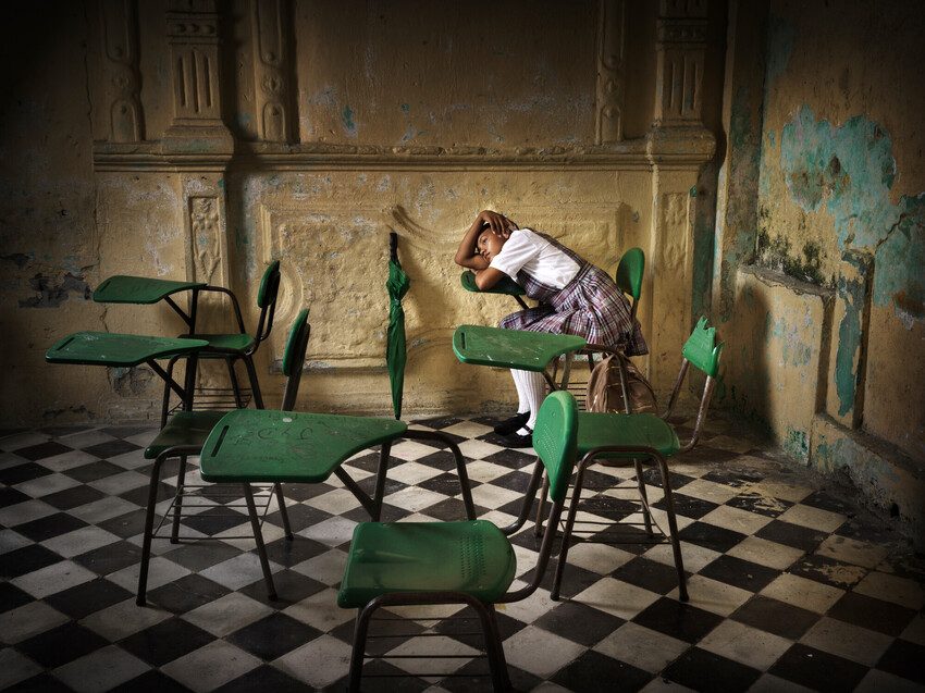 Katarina, 13, sits in her dilapidated classroom.