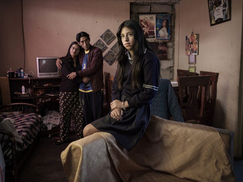 Erika is watched over by her two loving parents in their homely living room.