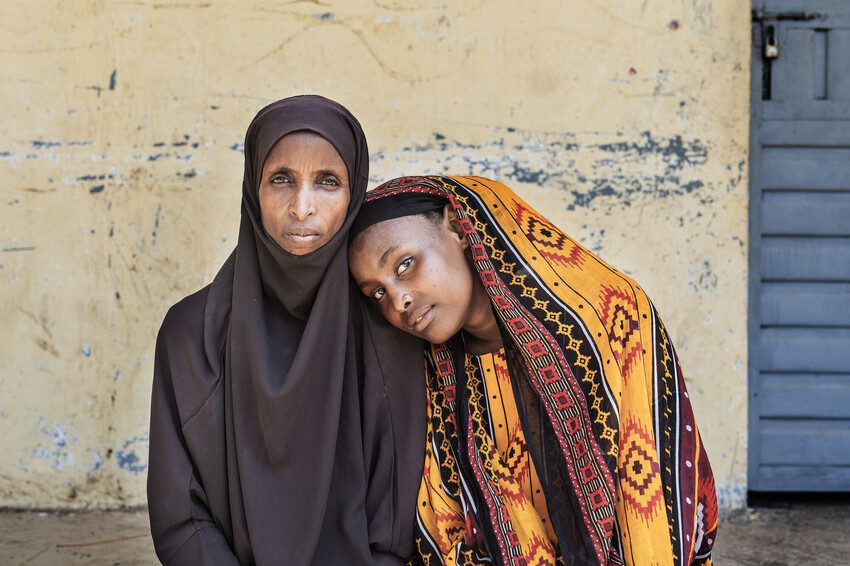 Zehara, teacher and community educator sits with her daughter Fatuma, 14.