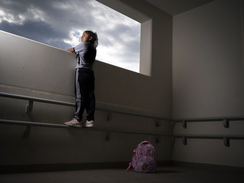 Alicia, 12, looks out over her balcony, she stands on railing as she is not tall enough otherwise. She is confident as she looks out into her future.
