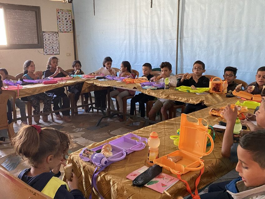 Children enjoy lunch at a learning space in Gaza.