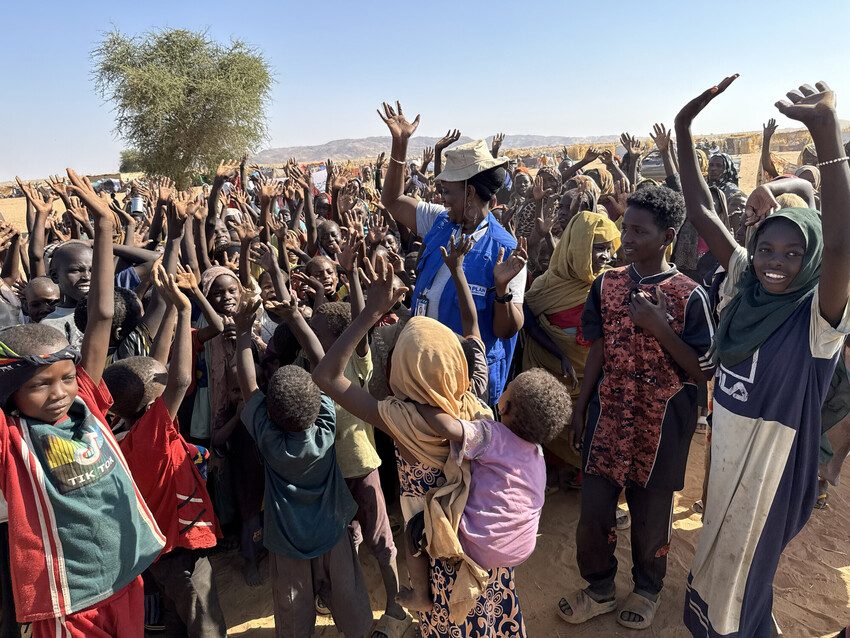Plan staff distribute humanitarian aid to children and families in Sudan.