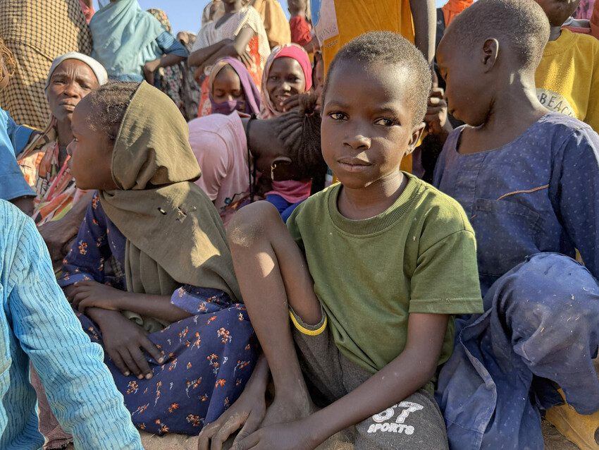 Plan staff distribute humanitarian aid to children and families in Sudan.