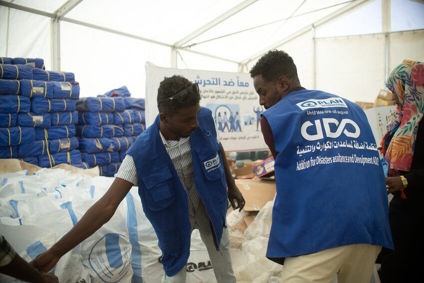 Plan staff distribute humanitarian aid to children and families in Sudan.