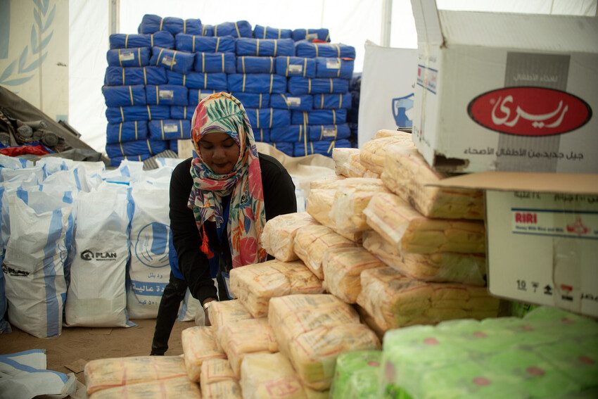 Plan staff distribute humanitarian aid to children and families in Sudan.