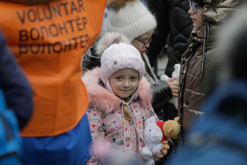 A Ukrainian refugee girl wearing a coat and hat in Romania