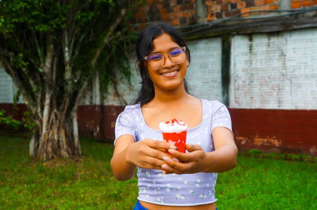 Rosa mostrando su idea de negocio con el batido de crema y fresas.