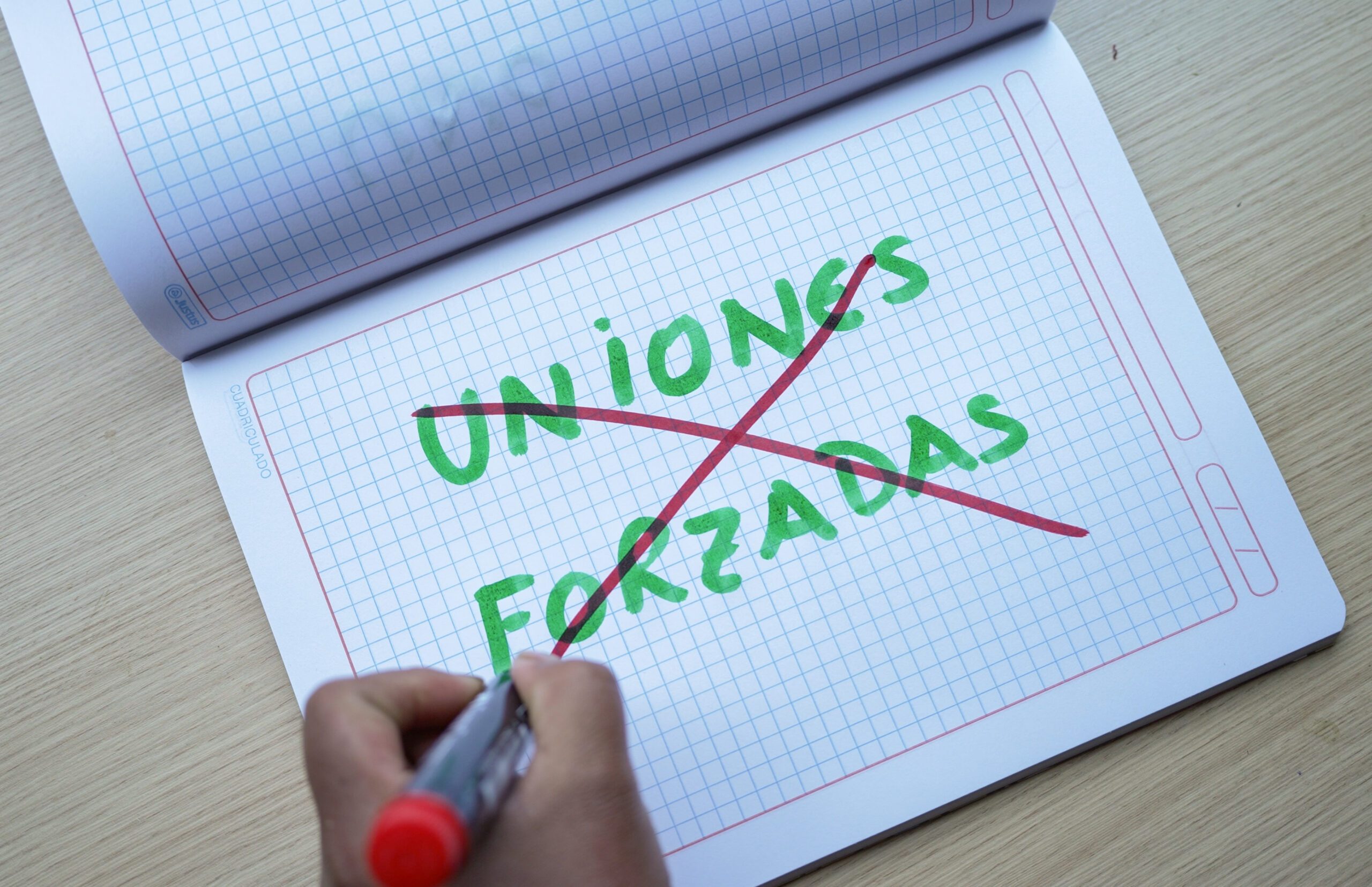 Cuaderno escrito con frase tachada de uniones forzadas