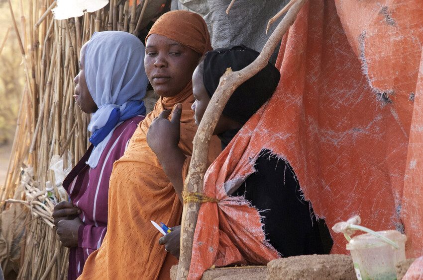 Sarra and 2 of her relatives outside their makeshift shelter in the camp. 