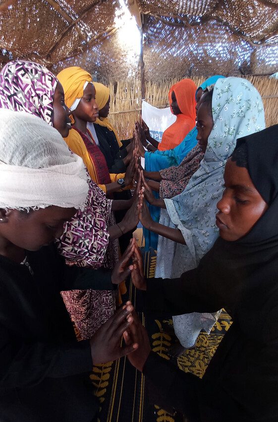 Adolescent girls touch hands as part of a wellbeing and stress management activity.