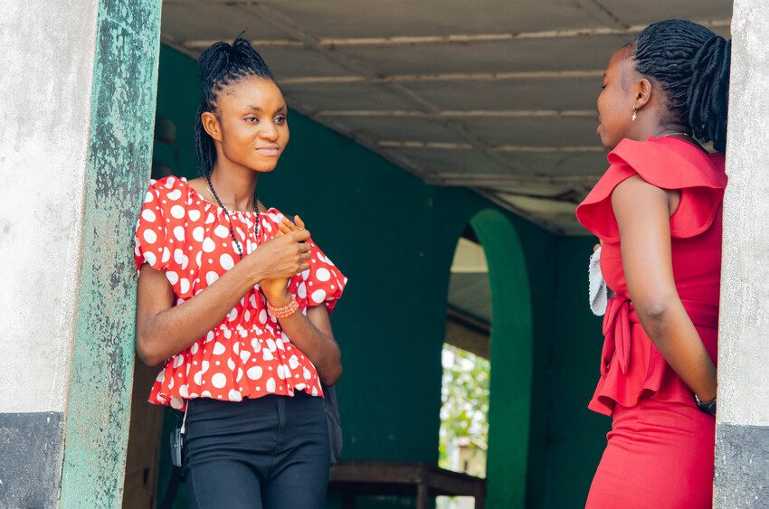 Eunice and Kumba stand in the doorway of their training centre.