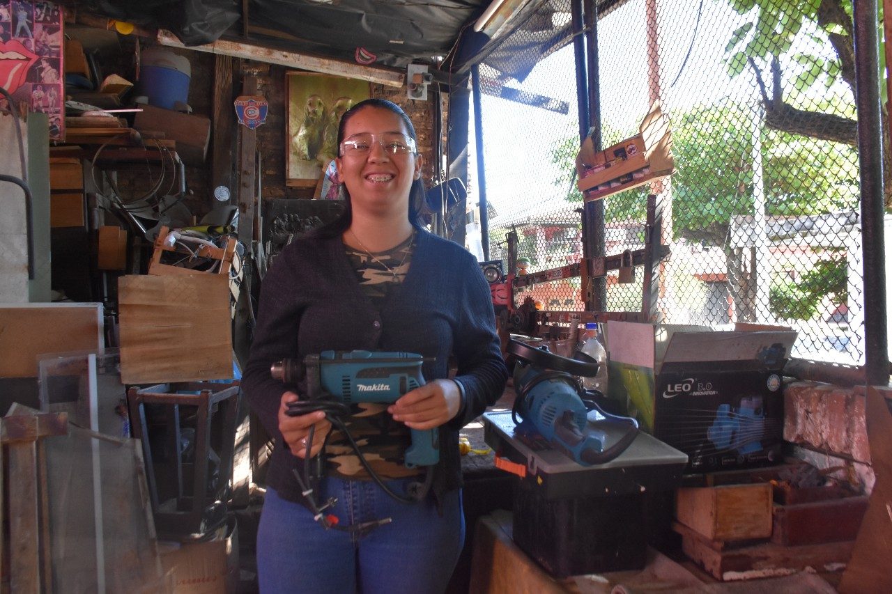 Ana holding a power tool.  