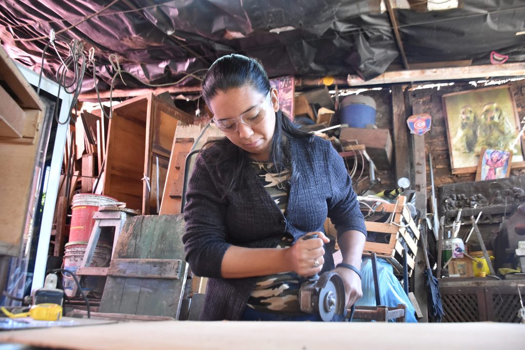 Ana working with tools in her workshop.